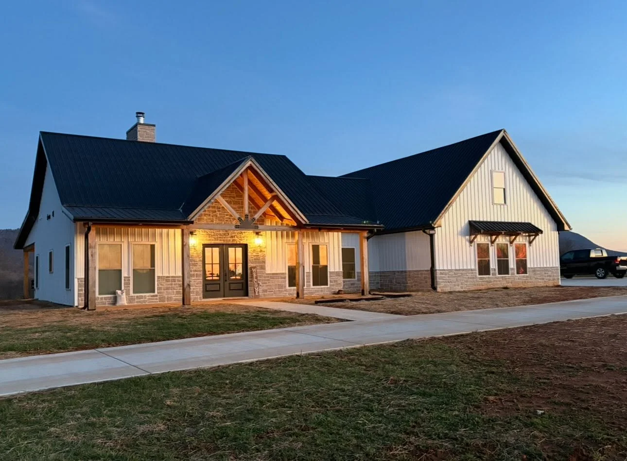 Warm porch lights illuminate a custom home at dusk, a Raschke & Sons Electric project